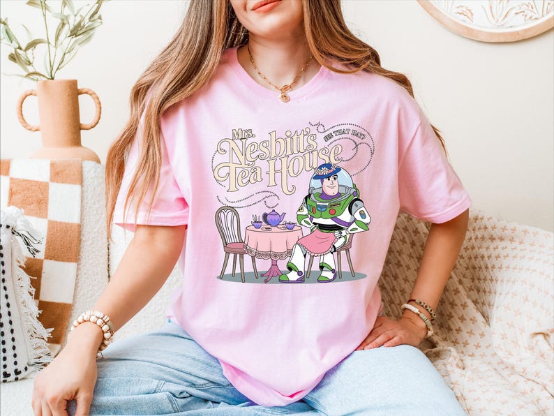 a woman sitting on a couch wearing a pink shirt