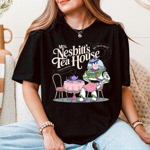 a woman sitting on a couch wearing a black tshirt