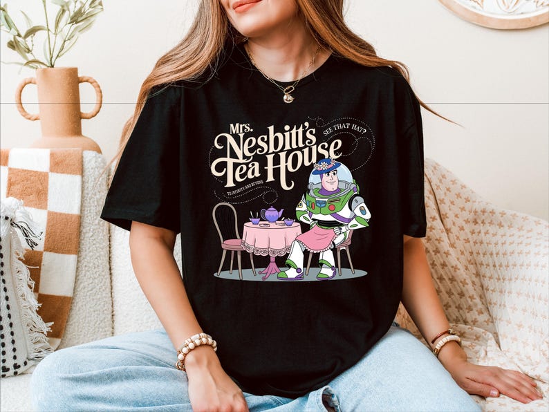 a woman sitting on a couch wearing a black tshirt