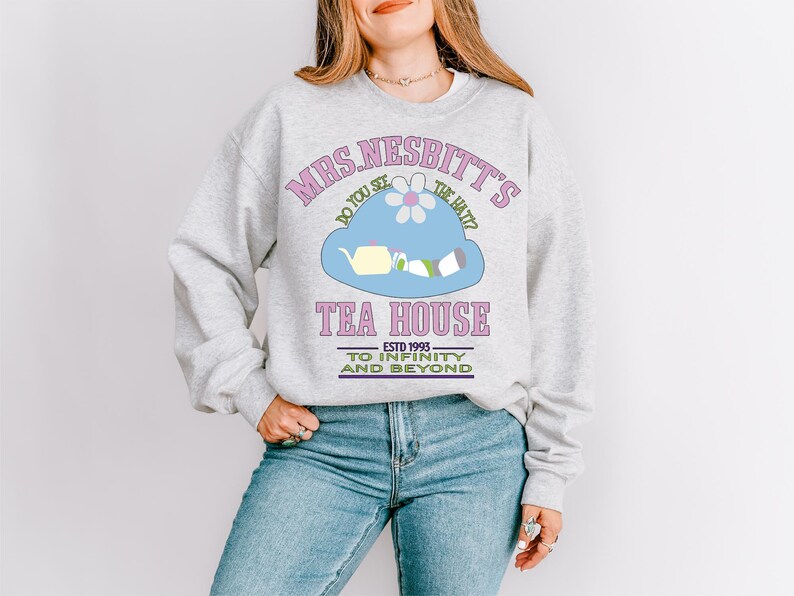 a woman wearing a sweatshirt with a tea house on it
