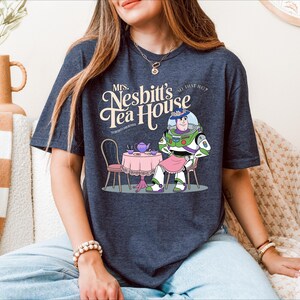 a woman sitting on a couch wearing a t - shirt