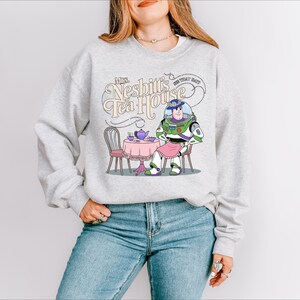 a woman wearing a sweatshirt with a cartoon character on it