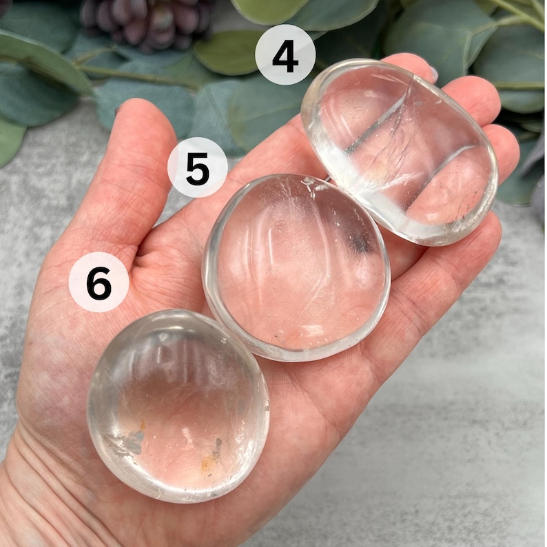 May include: Three clear quartz crystal coasters, each with a smooth, polished surface. The coasters are different sizes, with the largest being about 4 inches in diameter.