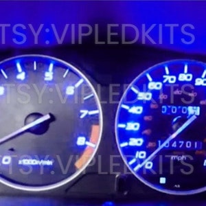 May include: Car dashboard with blue illuminated gauges. The speedometer reads 104701 mph. The tachometer shows a reading of 0. The image includes the text "ETSY: VIPLEDKITS".