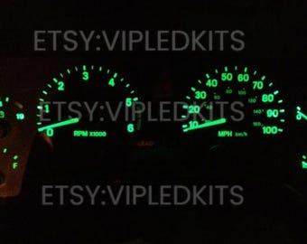May include: A car dashboard with green illuminated gauges. The gauges show RPM, speed, temperature, and fuel level. The text "ETSY:VIPLEDKITS" is visible on the dashboard.