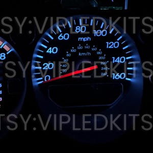May include: A car dashboard with blue LED lights. The speedometer reads 160 mph and the tachometer reads 8,000 rpm. The fuel gauge and temperature gauge are also visible.