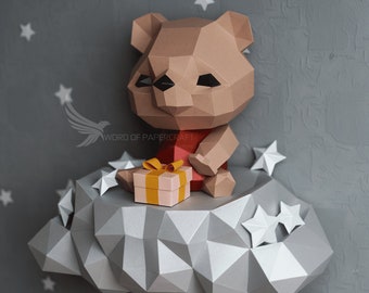 May include: A brown papercraft bear holding a yellow and pink gift box, sitting on a gray papercraft cloud with white stars on a gray background.