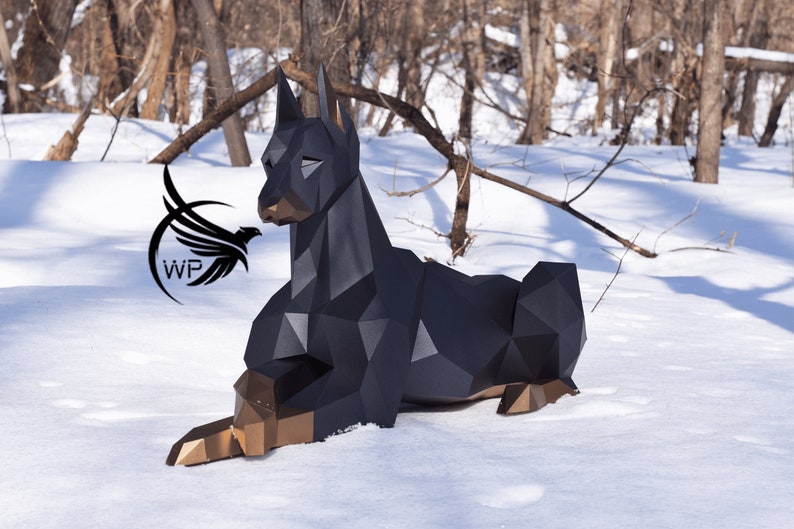 以下が含まれることがあります： 雪の中で横たわる犬の黒と金の幾何学的な彫刻。彫刻は多くの小さな三角形でできており、リアルな外観をしています。