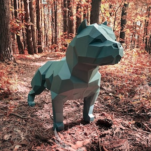 May include: A gray papercraft model of a pit bull dog standing in a forest with red and orange leaves on the ground.