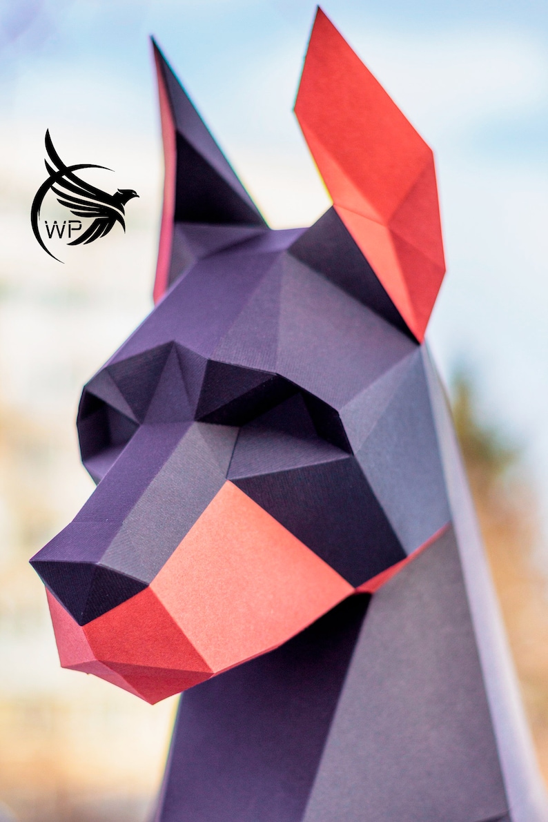 Peut inclure: Mod&egrave;le en papier d'une t&ecirc;te de chien Dobermann, en papier noir et rouge. Le mod&egrave;le est d&eacute;taill&eacute; et r&eacute;aliste, avec un nez pointu et des oreilles tombantes.