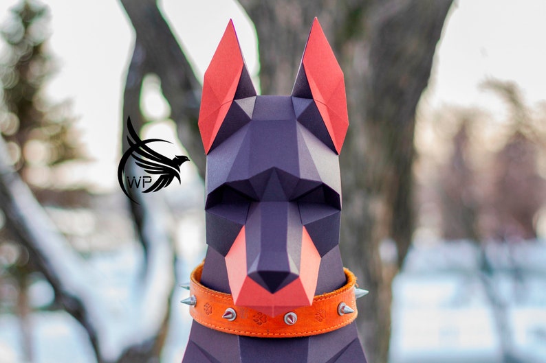 Peut inclure: Mod&egrave;le en papier d'une t&ecirc;te de chien Dobermann, en papier noir et orange, avec un collier en cuir orange &agrave; clous.
