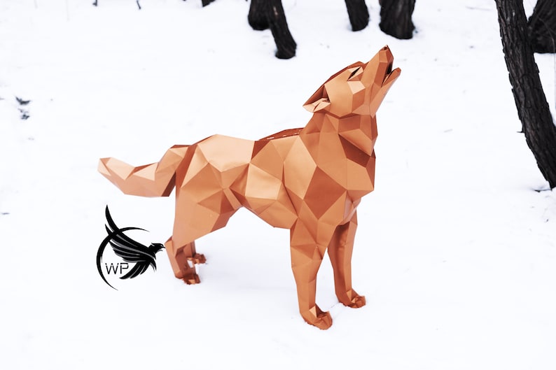 Puede incluir: Una escultura de origami de lobo de color cobre se encuentra sobre una superficie nevada. El lobo est&aacute; aullando con la cabeza echada hacia atr&aacute;s y la boca abierta. La escultura est&aacute; hecha de muchos tri&aacute;ngulos peque&ntilde;os que crean un patr&oacute;n geom&eacute;trico.