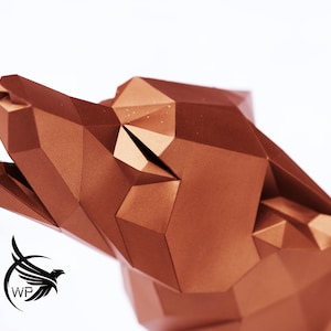 Puede incluir: Una escultura de cabeza de lobo de origami de color cobre con un dise&ntilde;o geom&eacute;trico. La boca del lobo est&aacute; abierta y su cabeza est&aacute; inclinada hacia arriba.