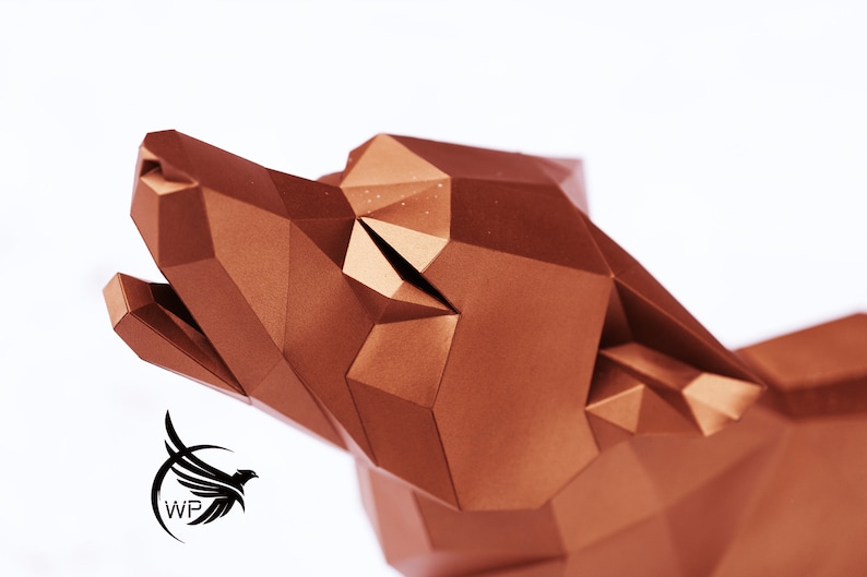 Puede incluir: Una escultura de cabeza de lobo de origami de color cobre con un dise&ntilde;o geom&eacute;trico. La boca del lobo est&aacute; abierta y su cabeza est&aacute; inclinada hacia arriba.