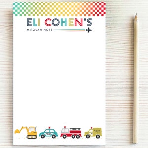 May include: A white notepad with a colorful checkered border and the text "Eli Cohen's Mitzvah Note" at the top. The bottom of the notepad features a row of colorful toy vehicles, including a yellow excavator, a blue police car, a red fire truck, and a green ambulance.