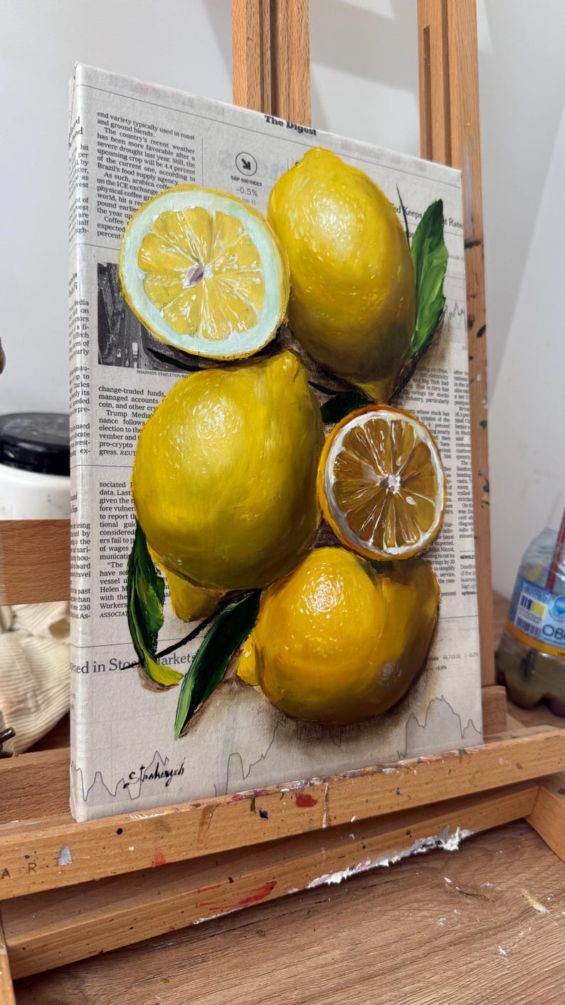 May include: A painting on canvas featuring several bright yellow lemons and two sliced lemon halves with visible segments. The fruit is depicted with green leaves against a background of printed newspaper text and financial market data.