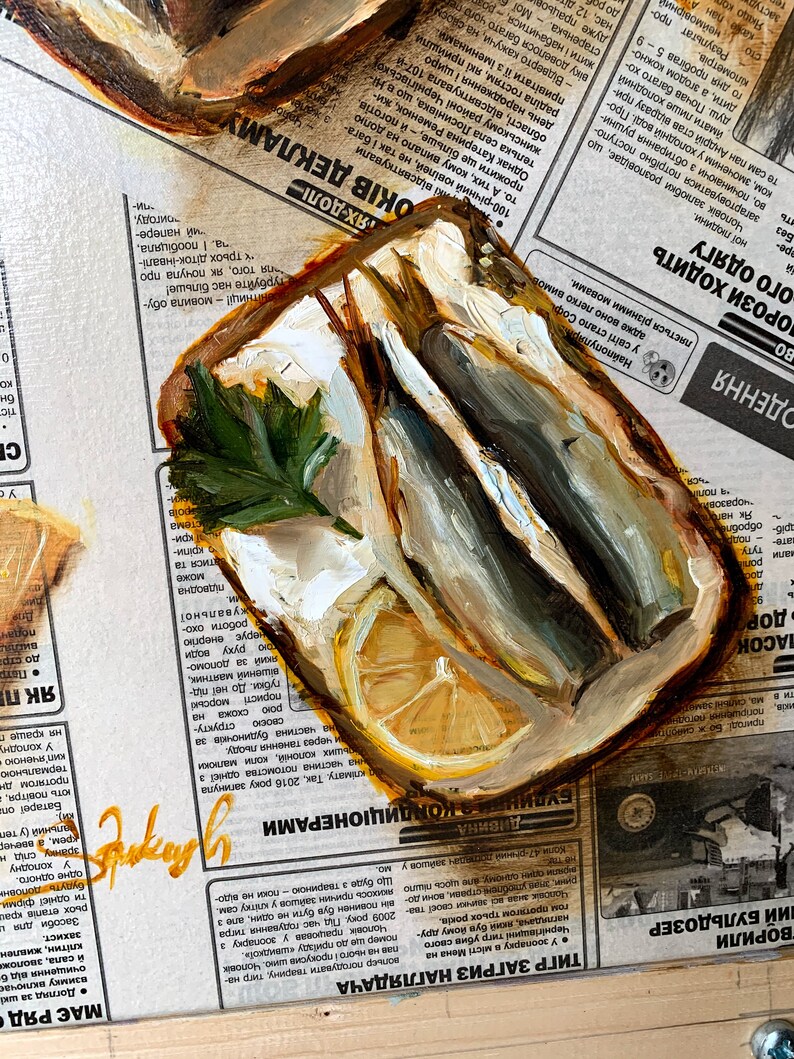 May include: A painting of a half-shell oyster with two sardines inside, a lemon wedge, and a sprig of parsley. The painting is on a newspaper background with text in Cyrillic.