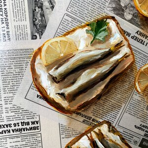 May include: A painting of two open-faced sandwiches with fish, butter, and parsley on top. The sandwiches are on a newspaper background with a lemon wedge on the side.