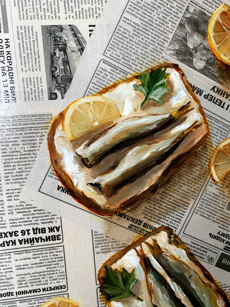 May include: A painting of two open-faced sandwiches with fish, butter, and parsley on top. The sandwiches are on a newspaper background with a lemon wedge on the side.
