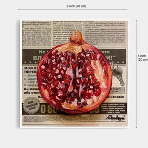 May include: A close-up of a painting of a halved pomegranate with red seeds and a white background. The painting is on top of a newspaper with text in a foreign language. The text includes the words "можливі переваги" and "Ваш унікальний шанс".