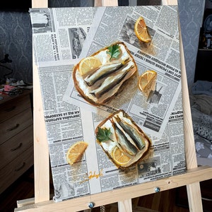 May include: A painting of two open-faced sandwiches with sardines, lemon slices, and parsley on a newspaper background.