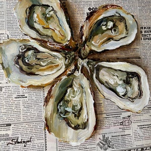 May include: A close-up of five oyster shells painted in shades of brown, white, and green. The shells are arranged in a flower shape on top of a newspaper.