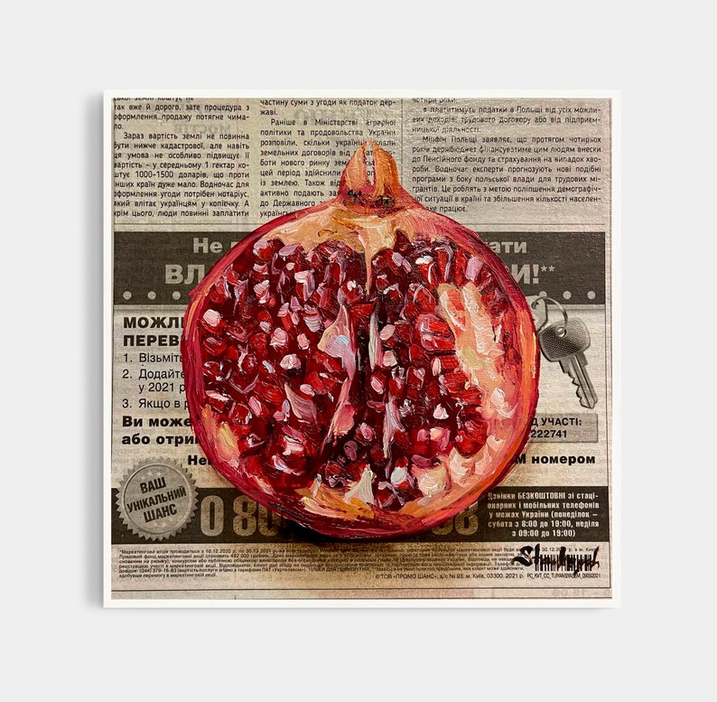 May include: A close-up of a red pomegranate cut in half, revealing the seeds inside. The pomegranate is painted on a vintage newspaper background with text in Ukrainian.