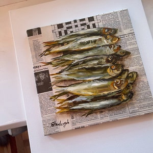 May include: A painting of a still life featuring a pile of silver fish on a newspaper background. The fish are arranged in a row, with their tails pointing to the right. The newspaper is printed in black and white, and the text is visible. The painting is done in a realistic style, with the fish and the newspaper rendered in detail.