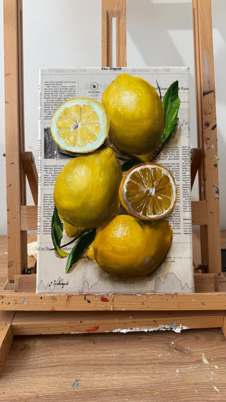 May include: A painting on a canvas featuring bright yellow lemons and green leaves. The composition includes two whole lemons and two halved lemons with visible segments. The background consists of printed newspaper text and columns.