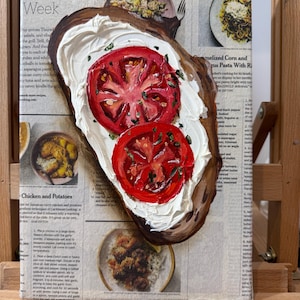 May include: A painting of a slice of bread topped with white cream and two red tomato slices. The painting is on a magazine page with a recipe for chicken and potatoes. The magazine's title is "Cooking".