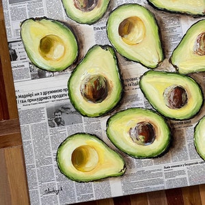 May include: A painting of a still life featuring a collection of avocados on a newspaper background. The avocados are arranged in a cluster, with some cut open to reveal their green flesh and brown seeds. The painting is done in a realistic style, with visible brushstrokes.
