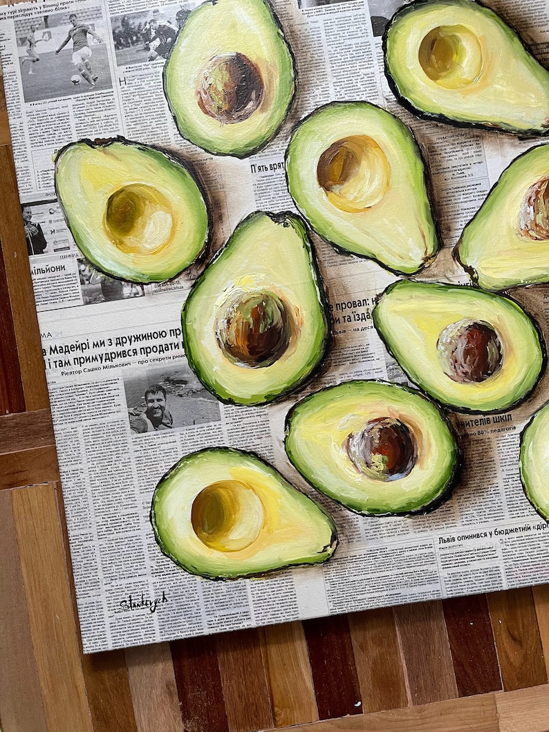 May include: A painting of a still life featuring a collection of avocados on a newspaper background. The avocados are arranged in a cluster, with some cut open to reveal their green flesh and brown seeds. The painting is done in a realistic style, with visible brushstrokes.