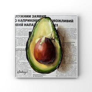 May include: A painting of a halved avocado with a green exterior and a brown pit. The avocado is painted on top of a newspaper article with the text "ЛУЖНИИ ЗАЯВИВ О НАПРИКІНИ ВИЙ НАПАД" and "ЗВІЛЬНЕННЯ КРИМУ - ЦЕ РЕАЛЬНІСТЬ."
