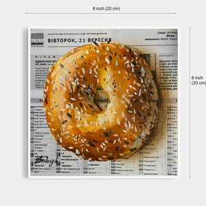 May include: A close-up of a bagel with sesame seeds painted on a newspaper background. The newspaper headline reads "ВІВТОРОК, 21 ВЕРЕСНЯ".