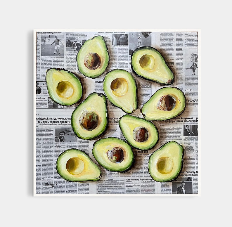May include: A painting of a still life featuring a dozen avocados arranged on a newspaper background. The avocados are cut in half, revealing their green flesh and brown seeds. The newspaper is printed in black and white and features text in Russian.