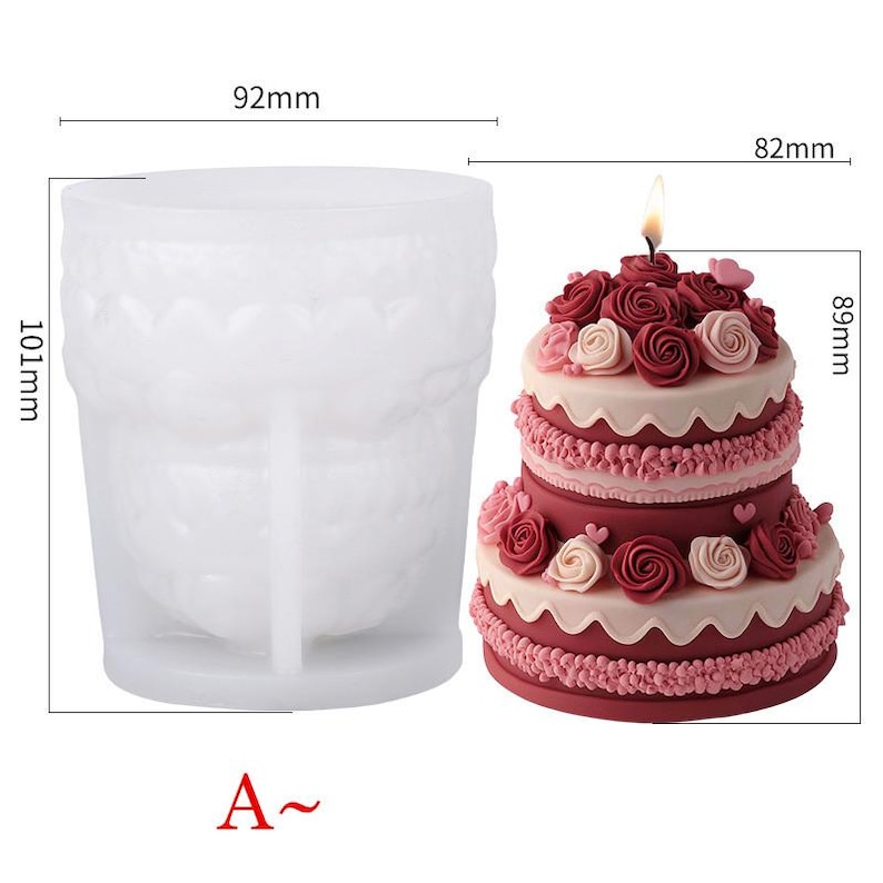 Puede incluir: Un molde de pastel de silicona blanco con forma de pastel de dos niveles, junto a un pastel de dos niveles decorado con glaseado rojo y rosa y rosas. El molde de pastel mide 101 mm de alto y 92 mm de ancho. El pastel mide 89 mm de alto y 82 mm de ancho.