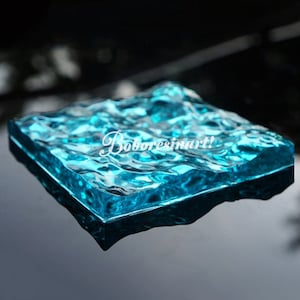 May include: A clear blue silicone mold with a wavy, rippled texture. The mold is designed to create a realistic water effect in resin crafts.