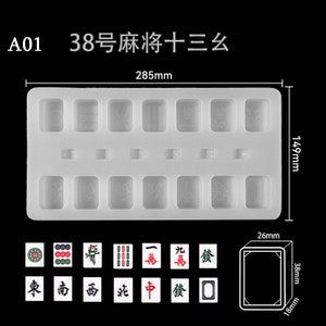 May include: A white silicone mould for making mahjong tiles. The mould has 13 rectangular spaces for the tiles, and the text "38号麻将十三么" is printed on the mould. The mould measures 29.5 cm by 15 cm.