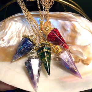 May include: Five gold chain necklaces with different colored resin crystal point pendants. The pendants are red, blue, purple, green, and iridescent.