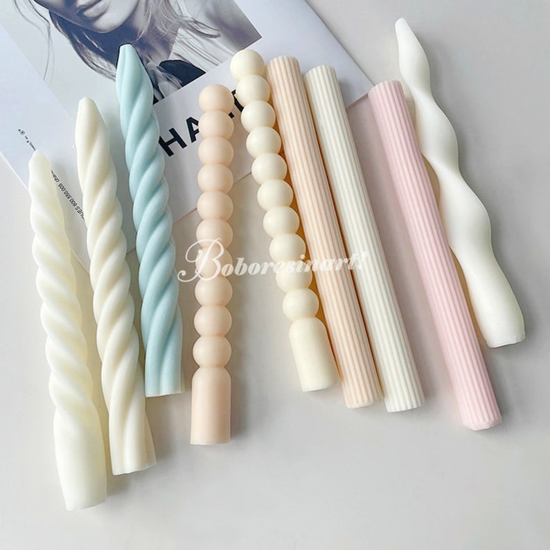 May include: A set of seven decorative candles in various pastel colors and designs. The candles are twisted, beaded, and ribbed.