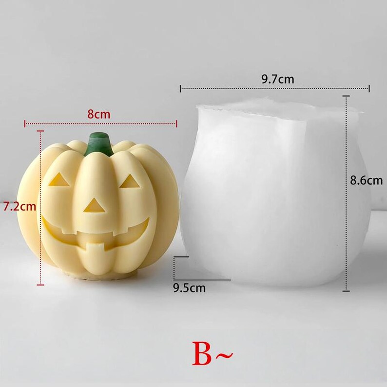 K&ouml;nnte beinhalten: Zwei Halloween-Motive. Eines ist ein hellgelber K&uuml;rbis mit einem geschnitzten Gesicht, 7,2 cm hoch und 8 cm breit. Das andere ist eine wei&szlig;e, vasenf&ouml;rmige Form, 8,6 cm hoch und 9,7 cm breit. Die Basis der K&uuml;rbisform ist 9,5 cm breit. Der Buchstabe "B~" befindet sich unten.