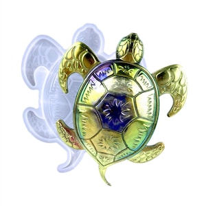 May include: A gold-coloured turtle mould with a detailed shell design. The mould is made of silicone and is perfect for creating resin crafts.