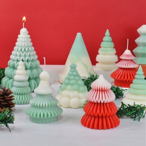Puede incluir: Surtido de velas de árbol de Navidad hechas a mano en varios colores y diseños. Las velas están hechas de cera y tienen una variedad de texturas, incluyendo lisas, texturizadas y onduladas. Las velas son perfectas para agregar un toque festivo a cualquier hogar.