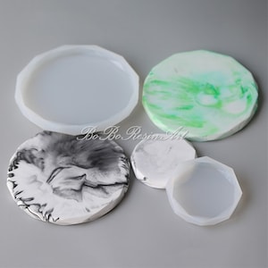 May include: Four silicone molds for resin crafts. The molds are round and have a slightly raised edge. The molds are in various sizes and are shown on a white surface.