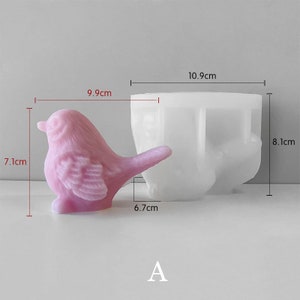 May include: A pink bird-shaped mould, 7.1 cm tall, next to a white mould. The bird mould is 9.9 cm long and 6.7 cm wide. The white mould is 10.9 cm wide and 8.1 cm tall. The letter "A" is at the bottom.