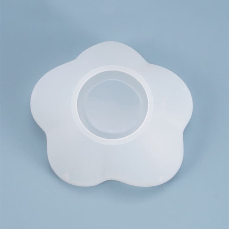 May include: White silicone mold shaped like a flower with a circular opening in the center.