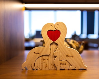 Puede incluir: Corte de madera de una familia de dinosaurios con un corazón rojo en el medio. Los dinosaurios están etiquetados como "Rose", "Mark", "Keith" y "Barry".