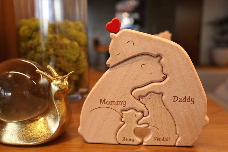 May include: Wooden bear family puzzle with a red heart on top. The bears are labeled "Mommy", "Daddy", "Henry", and "Kendall".