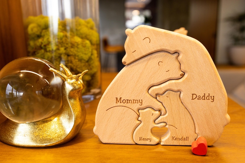 May include: Wooden bear family puzzle with the names Mommy, Daddy, Kendall, and Henry. The puzzle is made of light brown wood and has a natural finish.