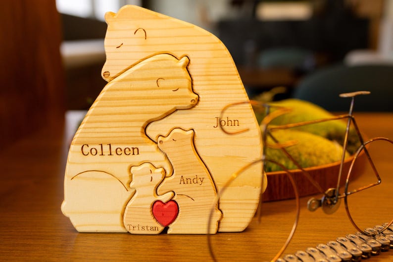 May include: Wooden bear family puzzle with the names Colleen, John, Andy, and Tristan. The bears are stacked on top of each other, with the largest bear at the bottom and the smallest bear at the top. The puzzle is made of natural wood and has a rustic look.